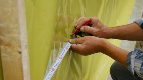 The man is engaged in construction work on the exterior isulation of the house with mineral wool The man is engaged in construction work on the exterior isulation of the house with mineral wool