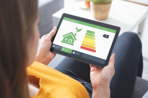 Energy efficiency mobile app on screen, eco house Energy efficiency mobile app on screen, eco house