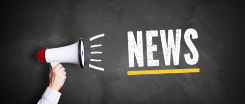 Hand mit Megafon und dem Wort News auf einer Kreidetafel Hand mit Megafon und dem Wort News auf einer Kreidetafel