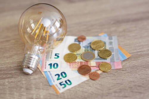 light bulb and euro money banknotes and coins light bulb and euro money banknotes and coins