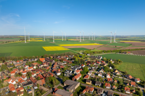 Conflits et espace de vie avec le paysage Village à côté de champs agricoles et d'éoliennes